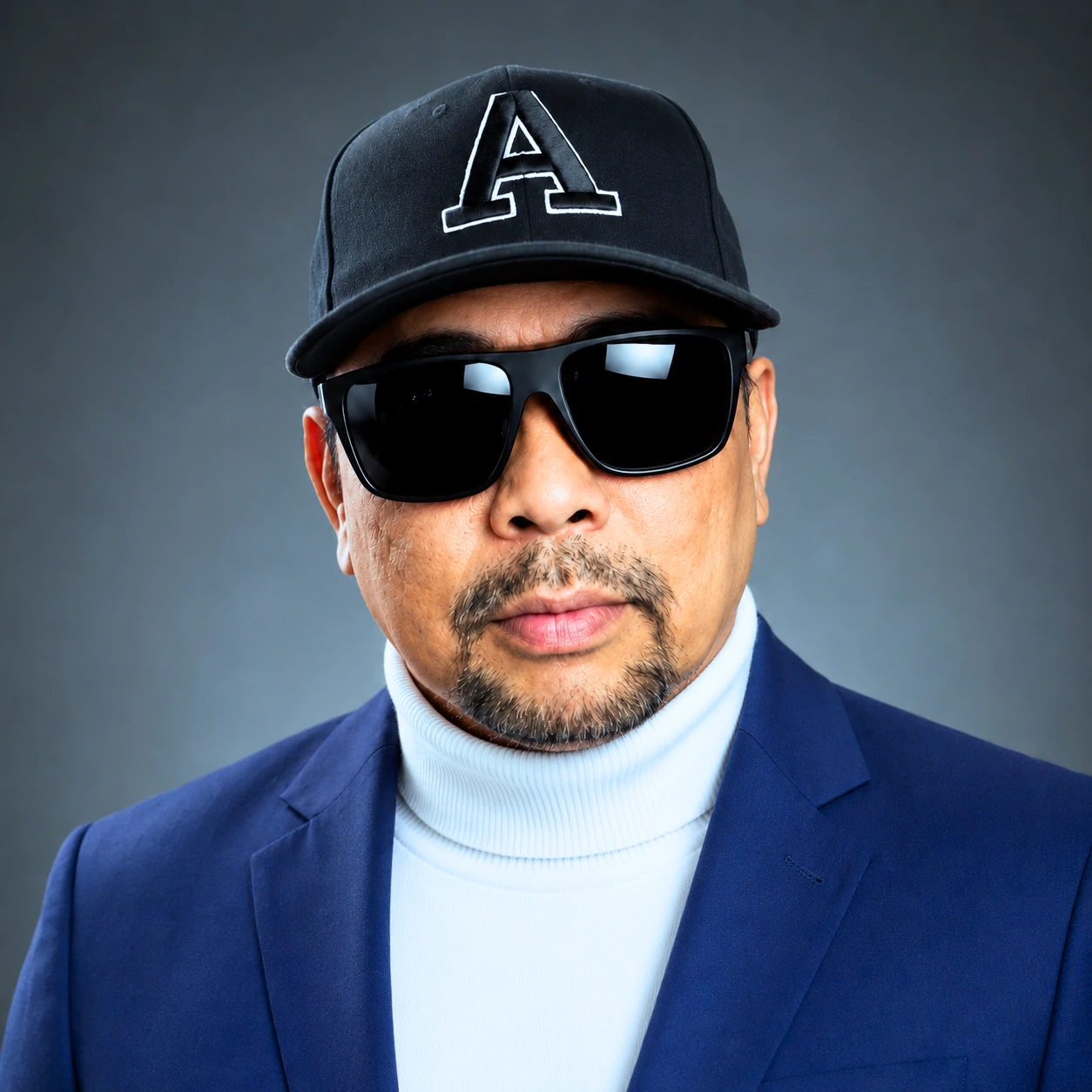 Portrait of Uncle Ayub in a navy blazer, white turtleneck and signature cap